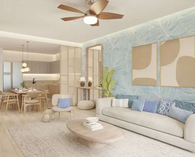 Sala de Village BLU con sofá blanco, cojines azules y comedor al fondo