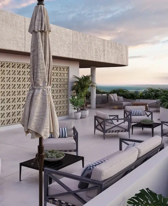 Terraza lounge en la azotea de Village BLU con sombrillas y vista al Caribe